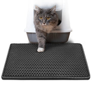 Gray cat stepping from a covered litter box onto a black double-layer honeycomb mat